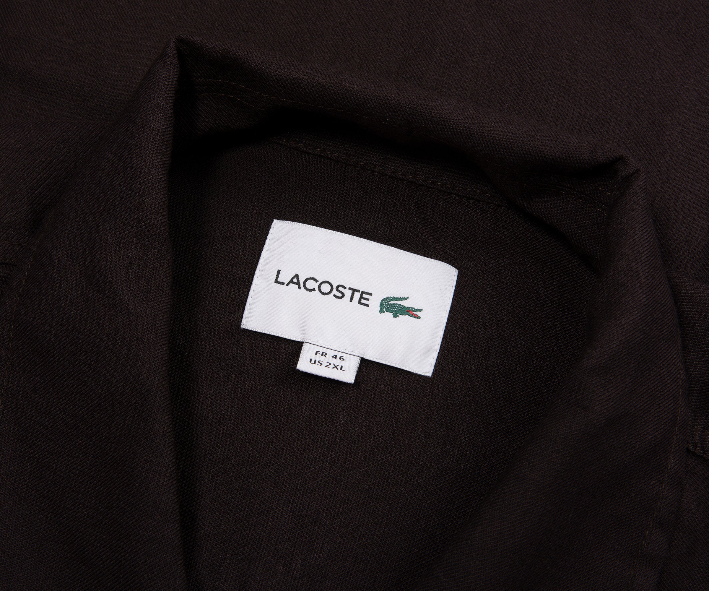 Close-up of a Lacoste label on a black shirt
