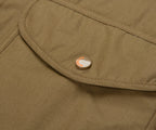 Close-up of a green jacket with a brand logo on a button.