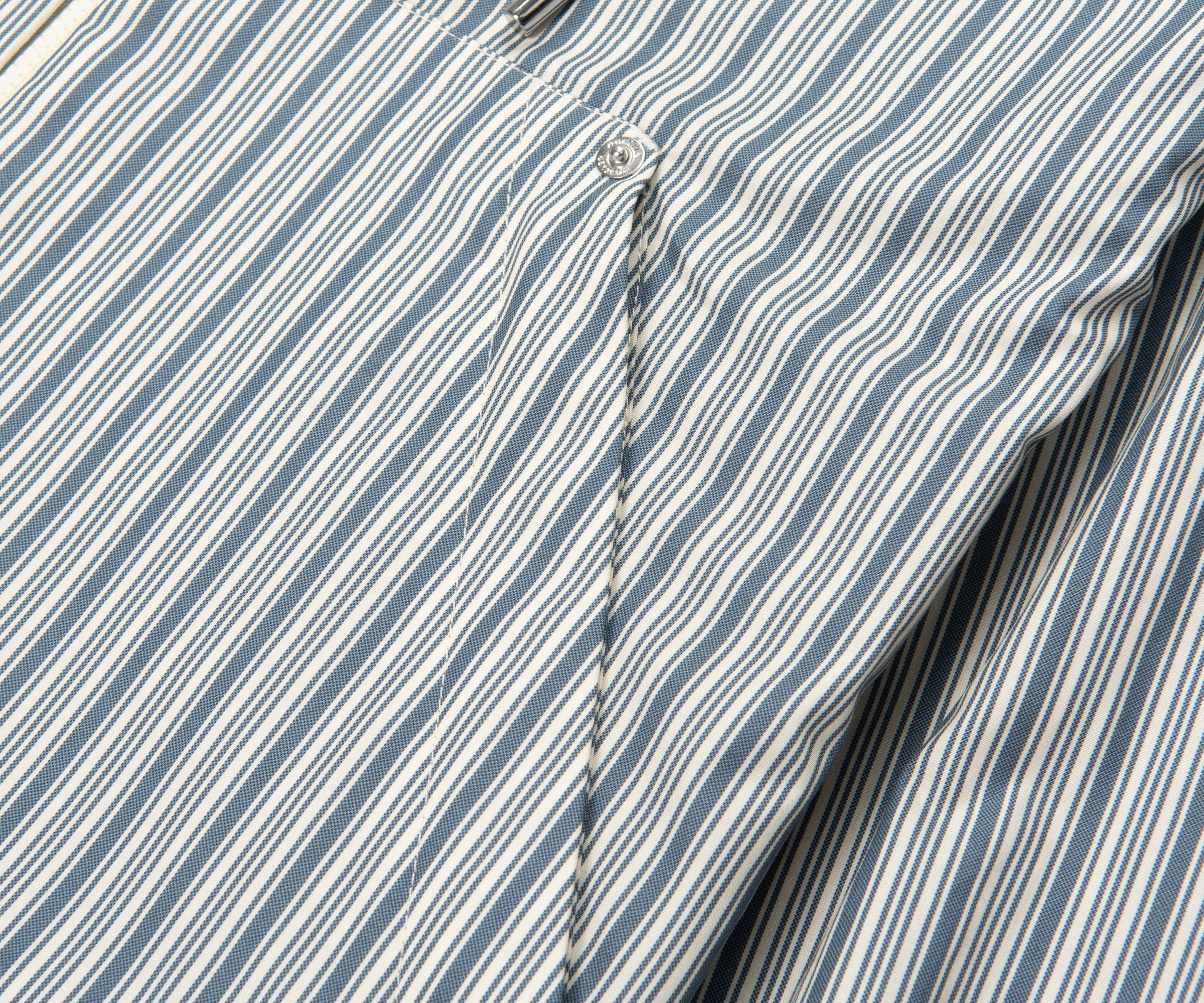 Close-up of a blue and white striped shirt with a button detail.