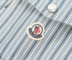 Close-up of a Moncler logo on a striped fabric background