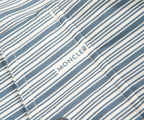 Close-up of a blue and white striped fabric with 'Moncler' branding.