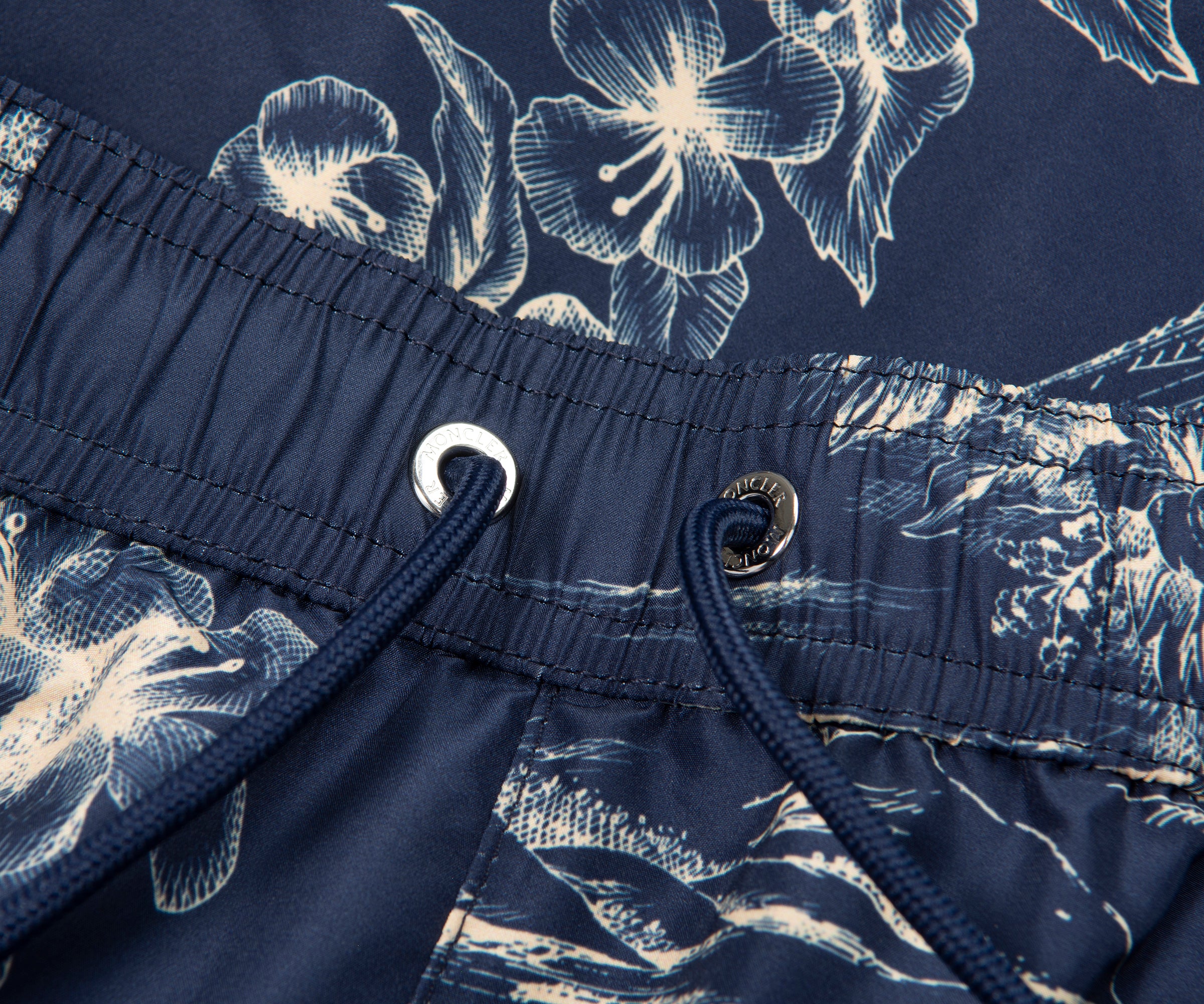 Navy blue swim shorts with white floral pattern and drawstring