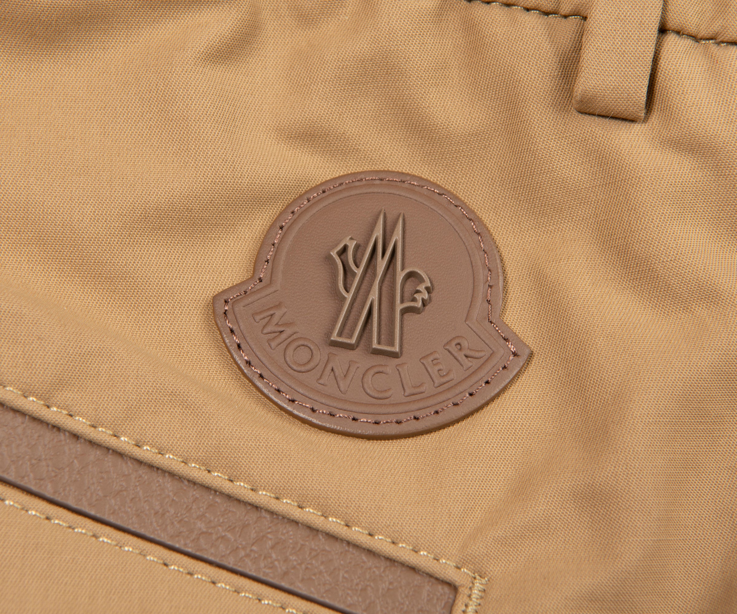 Close-up of a Moncler logo on a brown fabric background