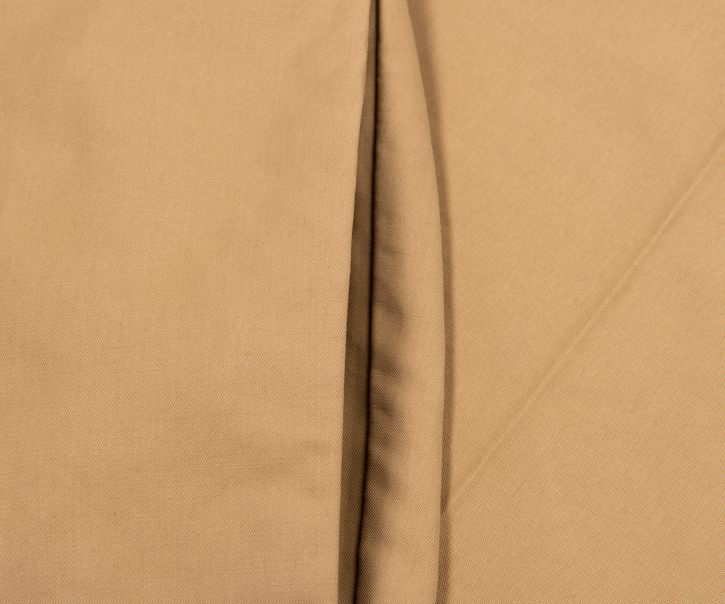 Close-up of beige fabric with a visible seam