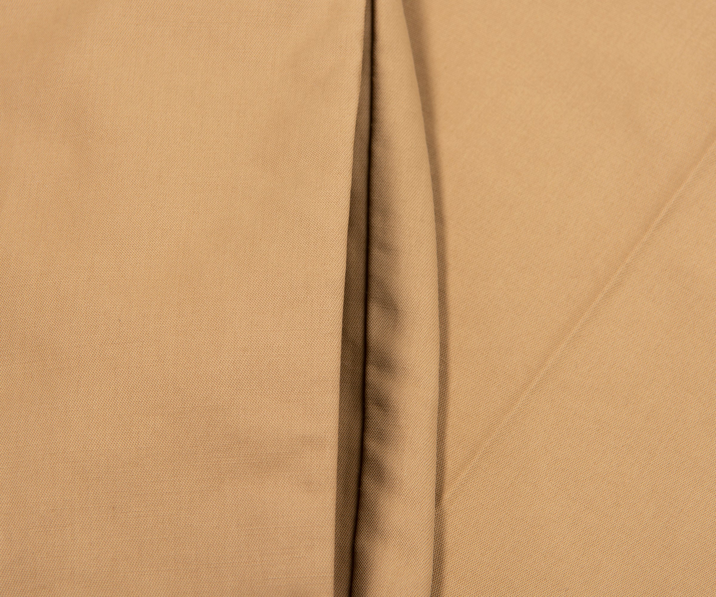 Close-up of beige fabric with a visible seam