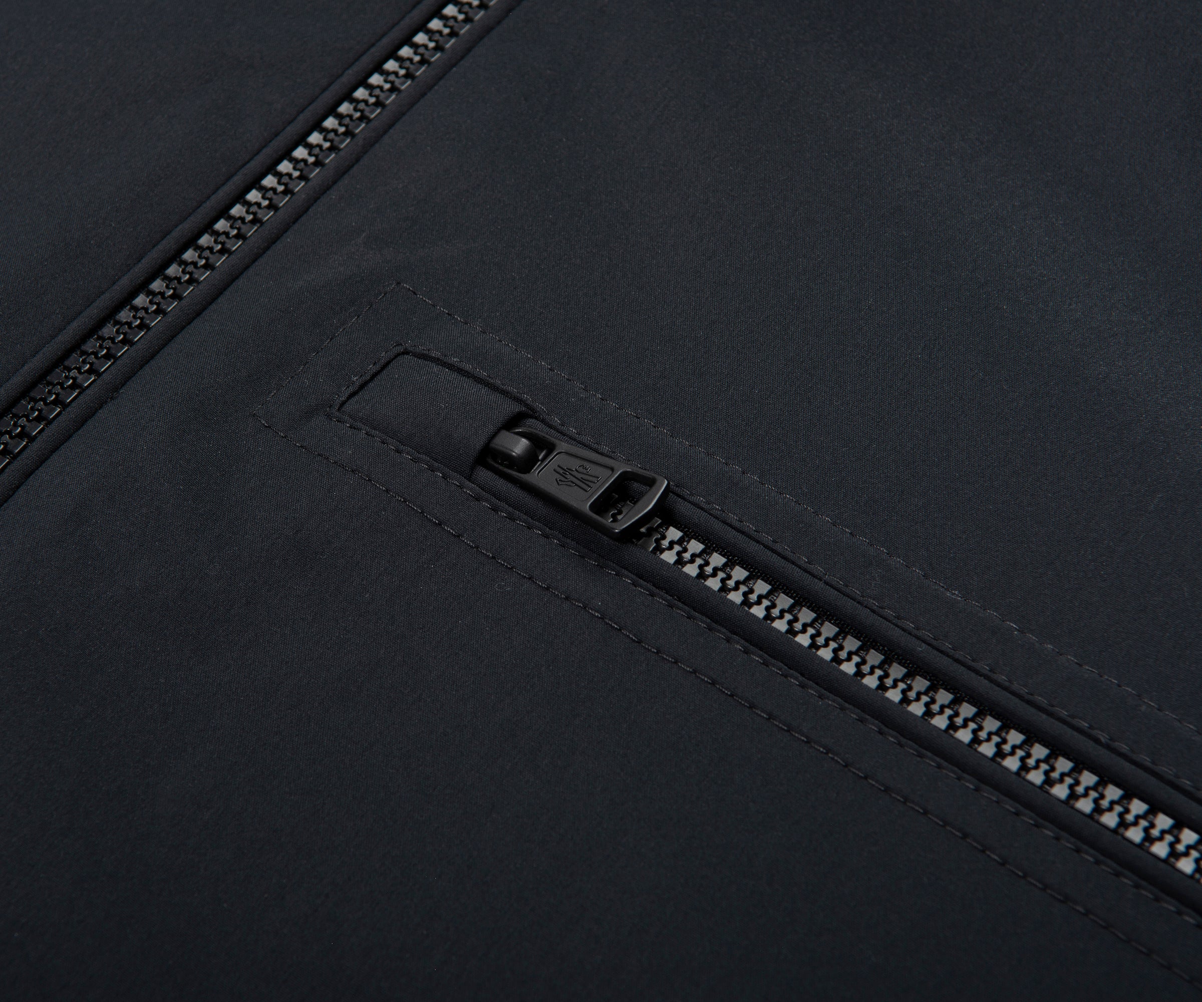 Close-up of a black zipper on a black fabric background