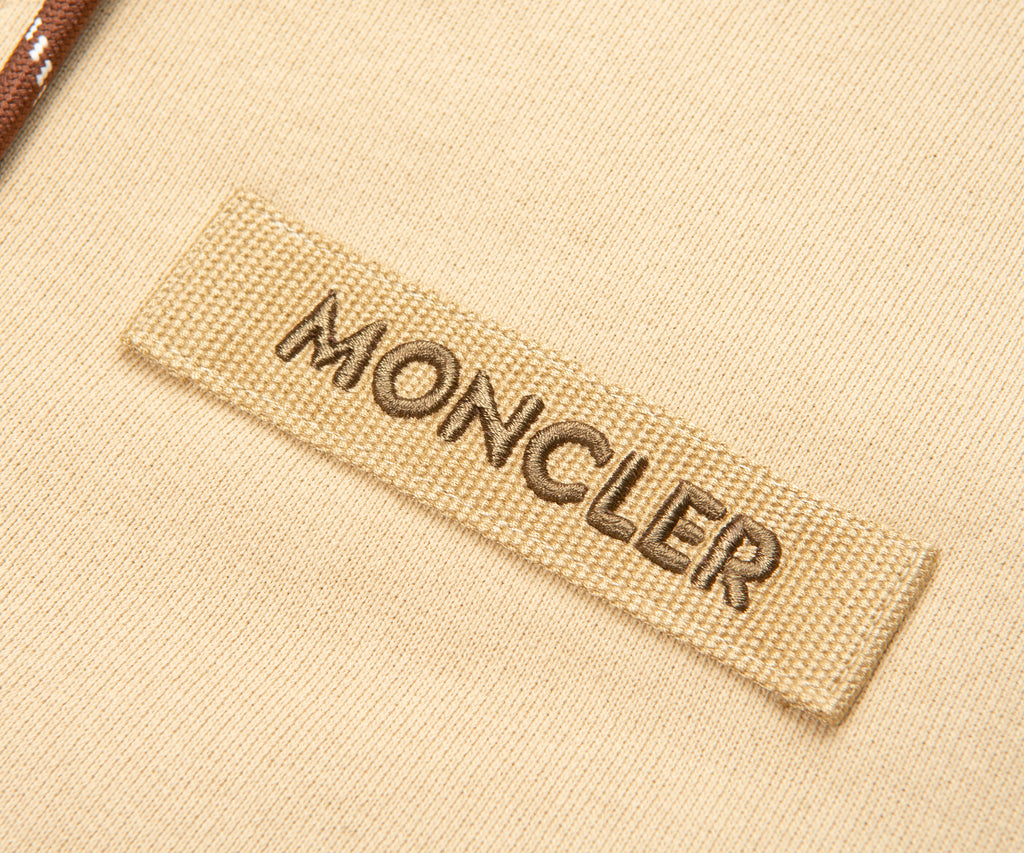 Moncler label on a beige fabric background