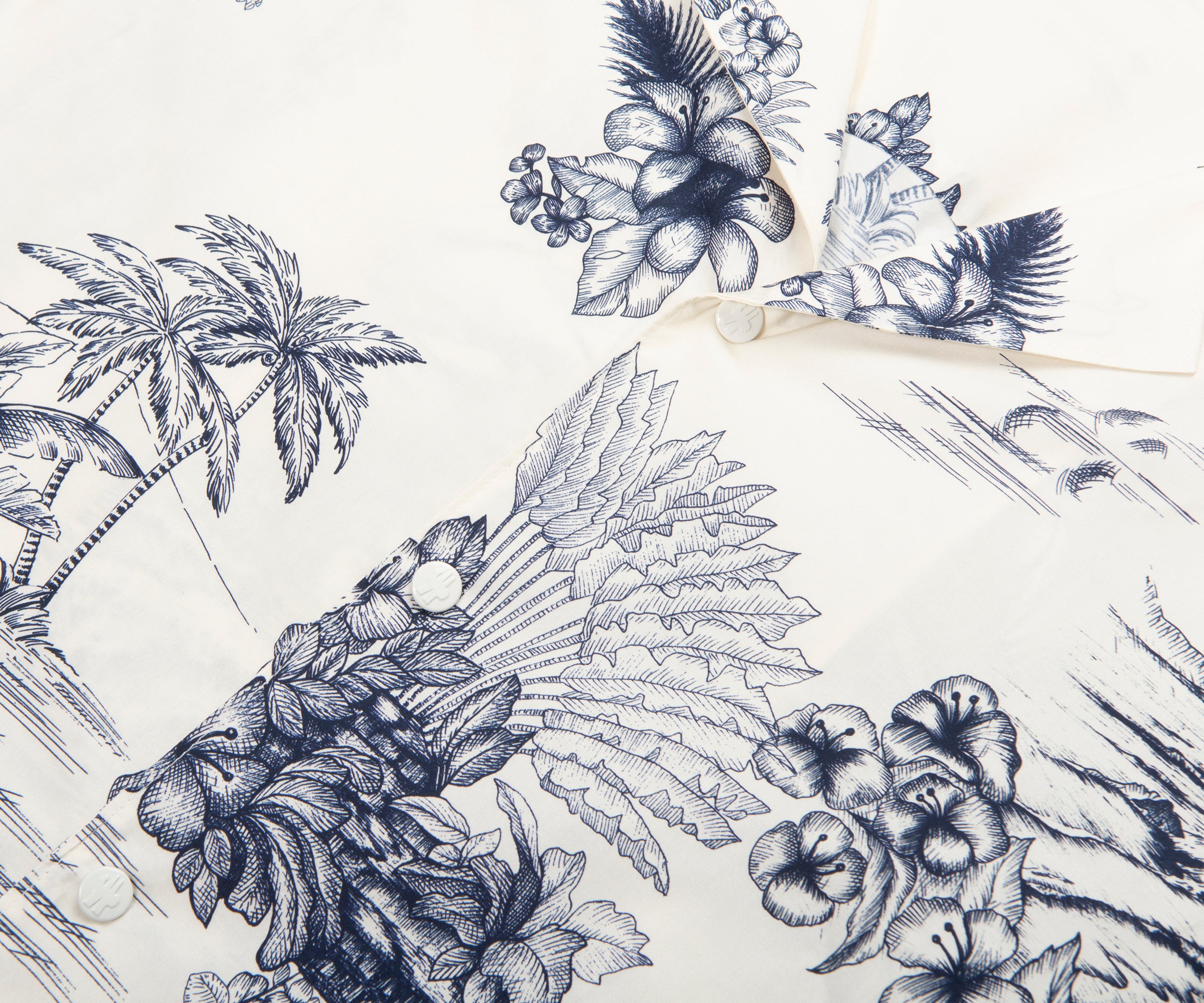 Close-up of a shirt with blue floral and palm tree pattern on a white background
