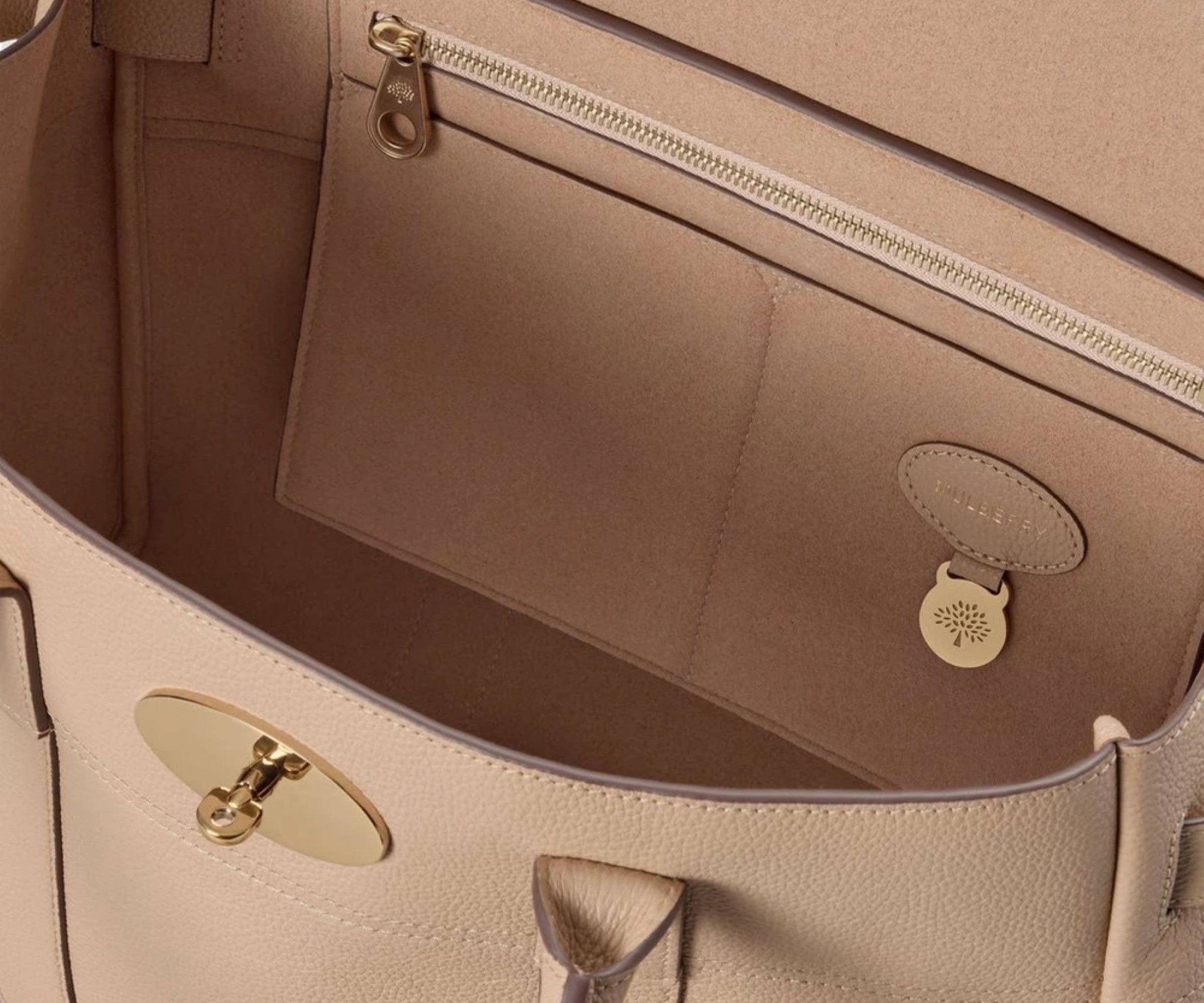 Close-up of a beige handbag with gold hardware