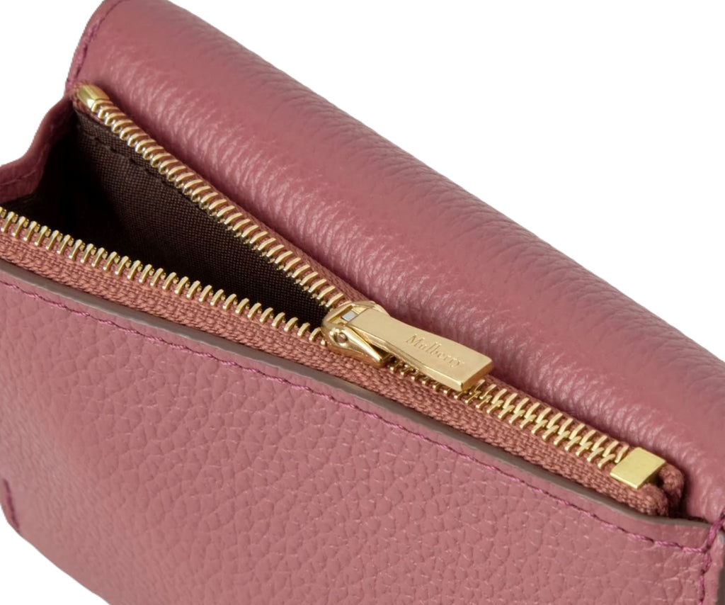 Pink leather pouch with gold zipper on a white background