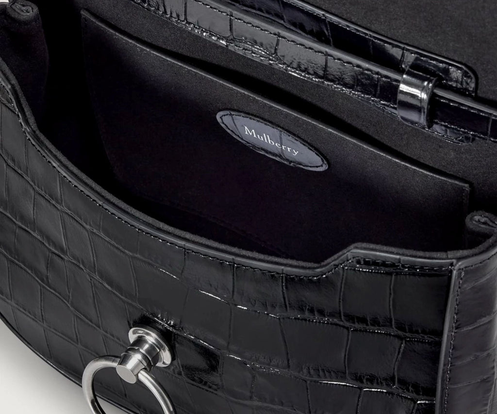 Close-up of a black handbag with 'Mulberry' branding on a white background