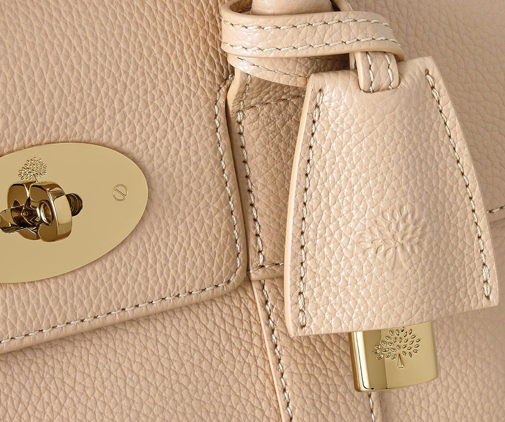 Close-up of a beige leather handbag with gold hardware