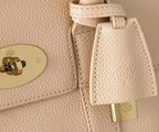 Close-up of a beige leather handbag with gold hardware