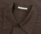 Close-up of a brown jacket collar with a button and label.