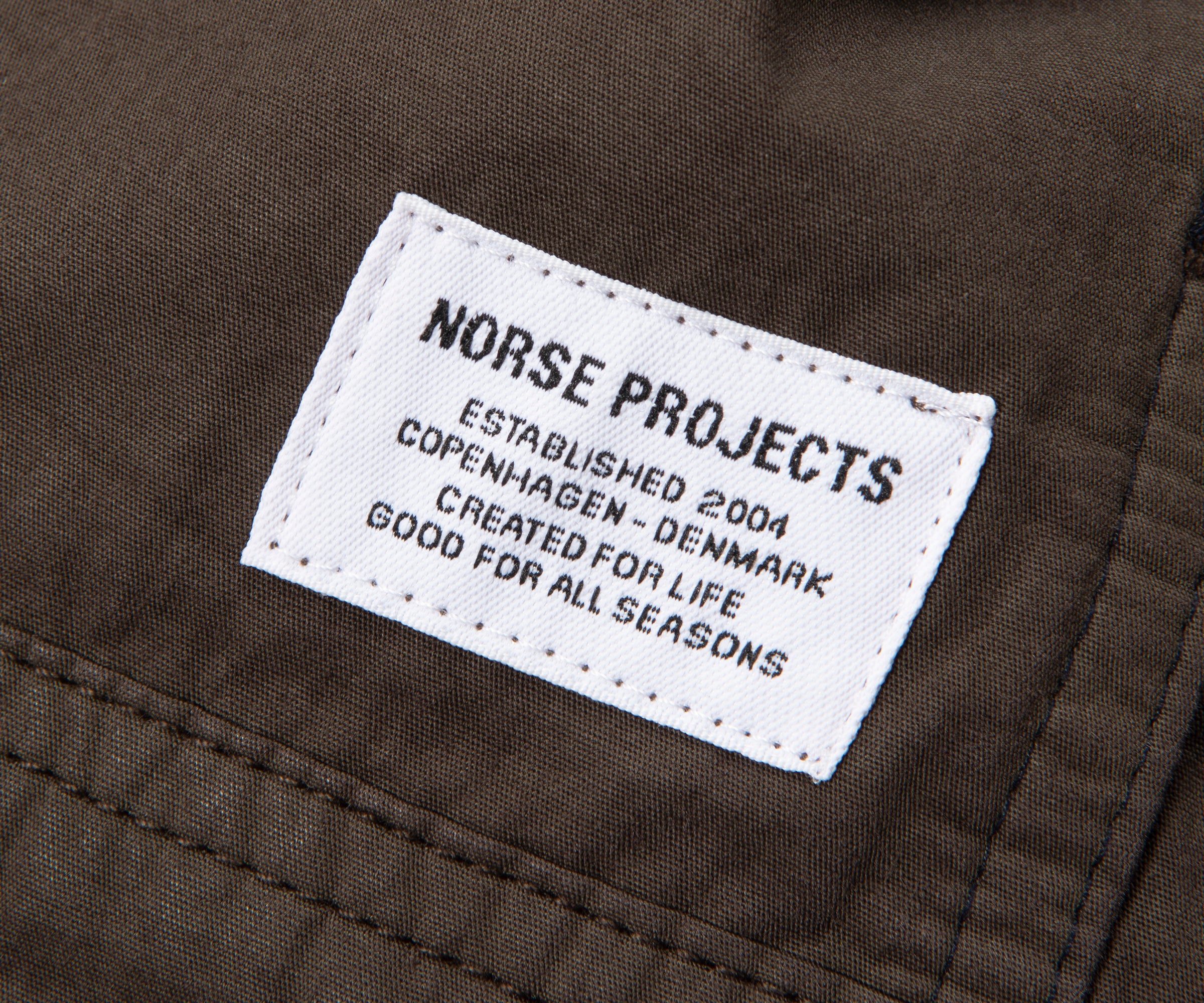 Norse Projects label on a brown fabric background