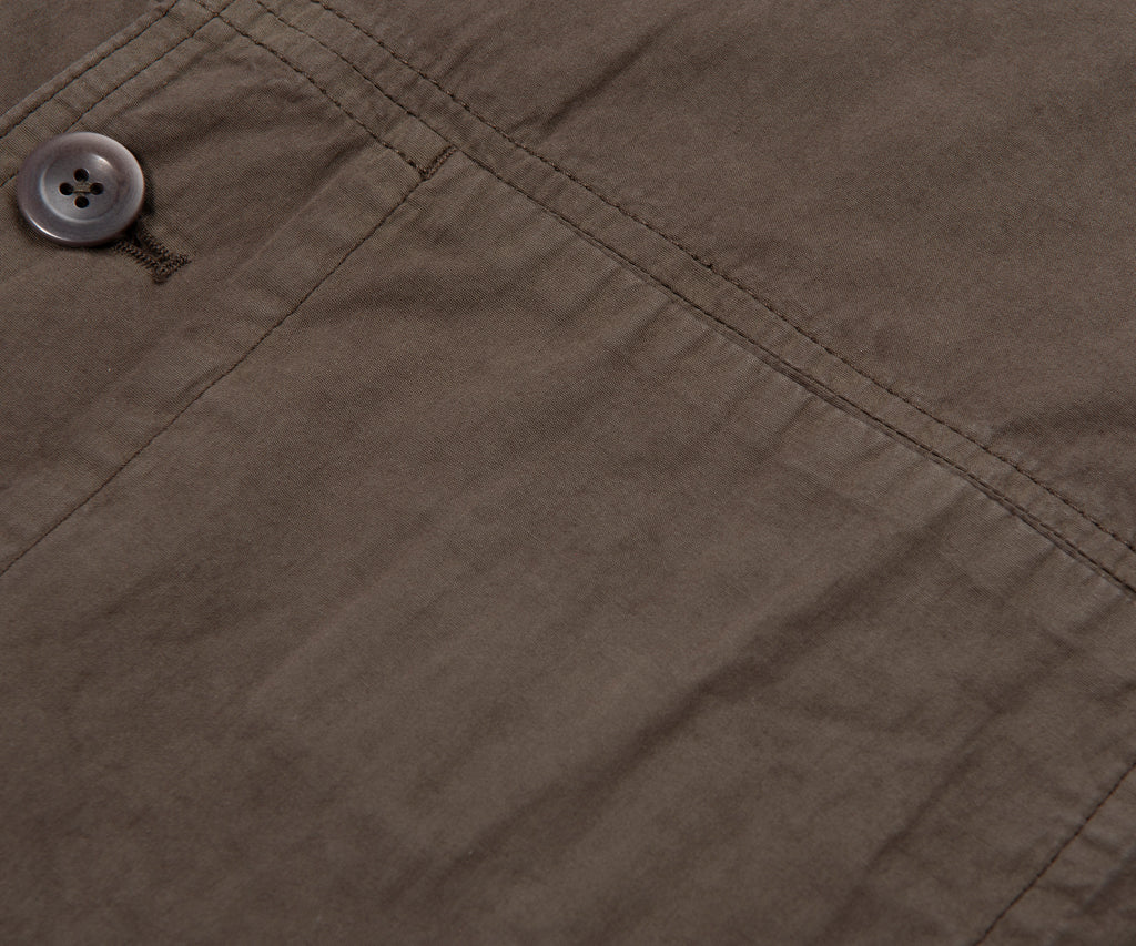 Close-up of a button on a brown fabric surface