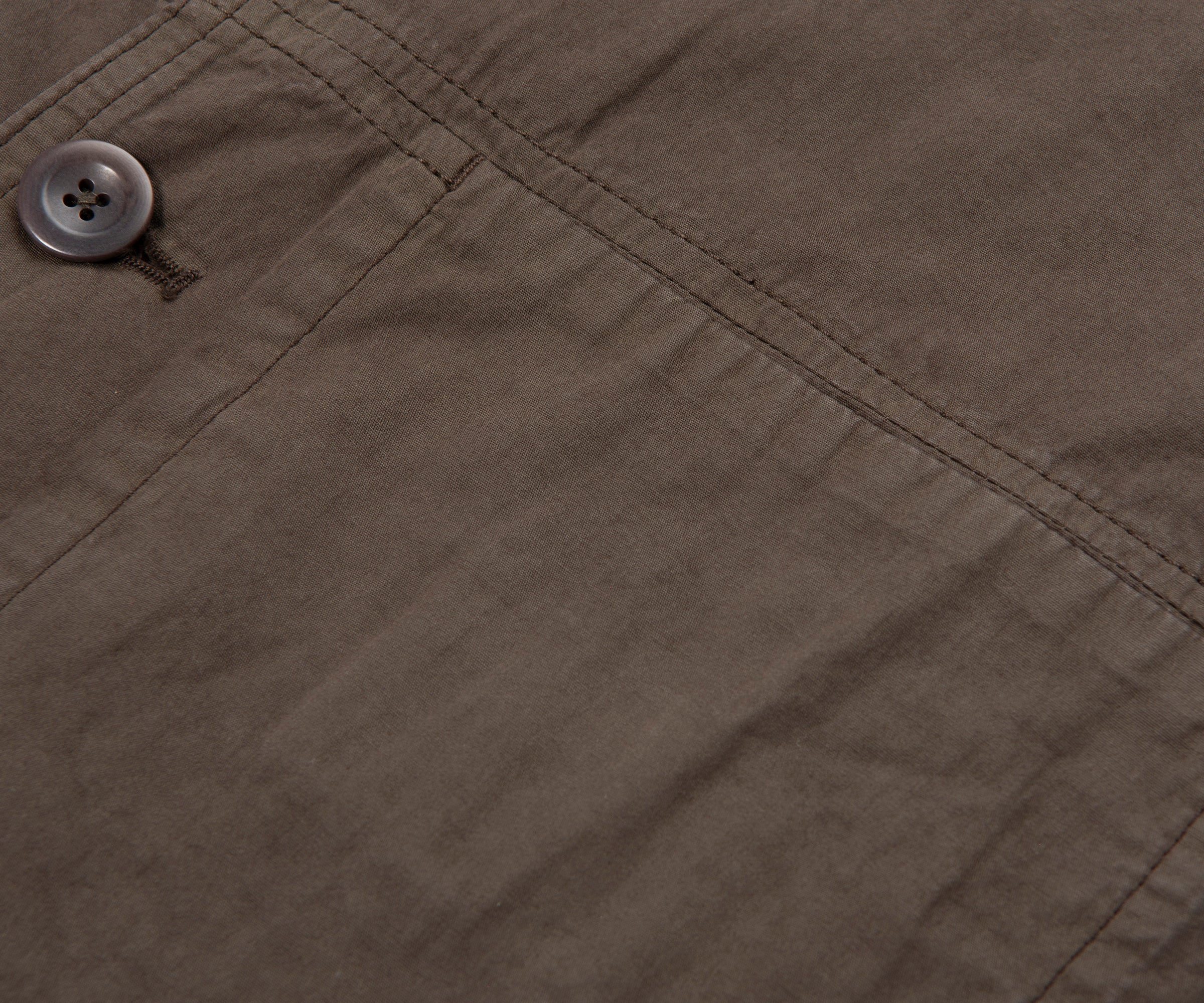 Close-up of a button on a brown fabric surface