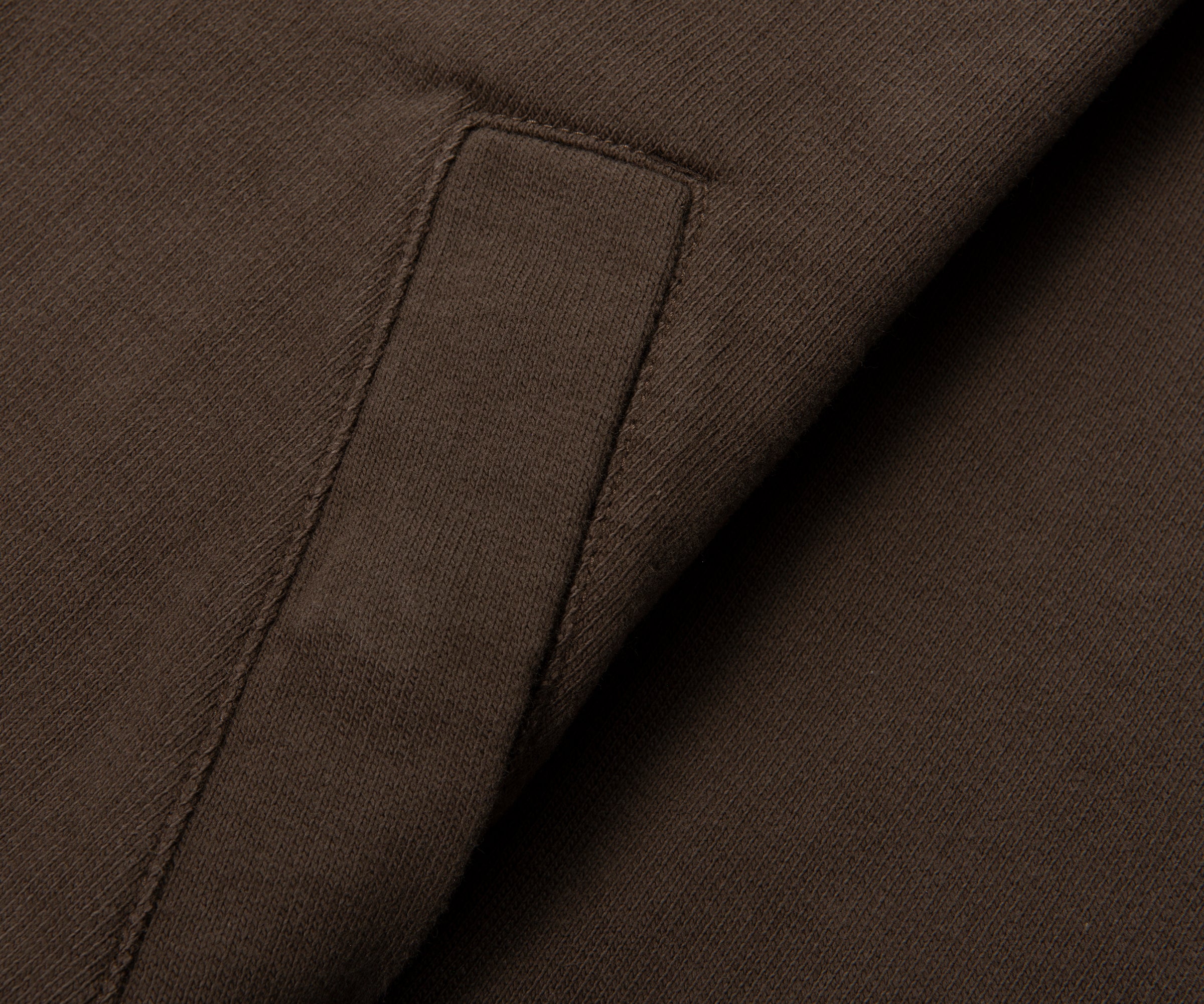 Close-up of brown fabric with a pocket detail