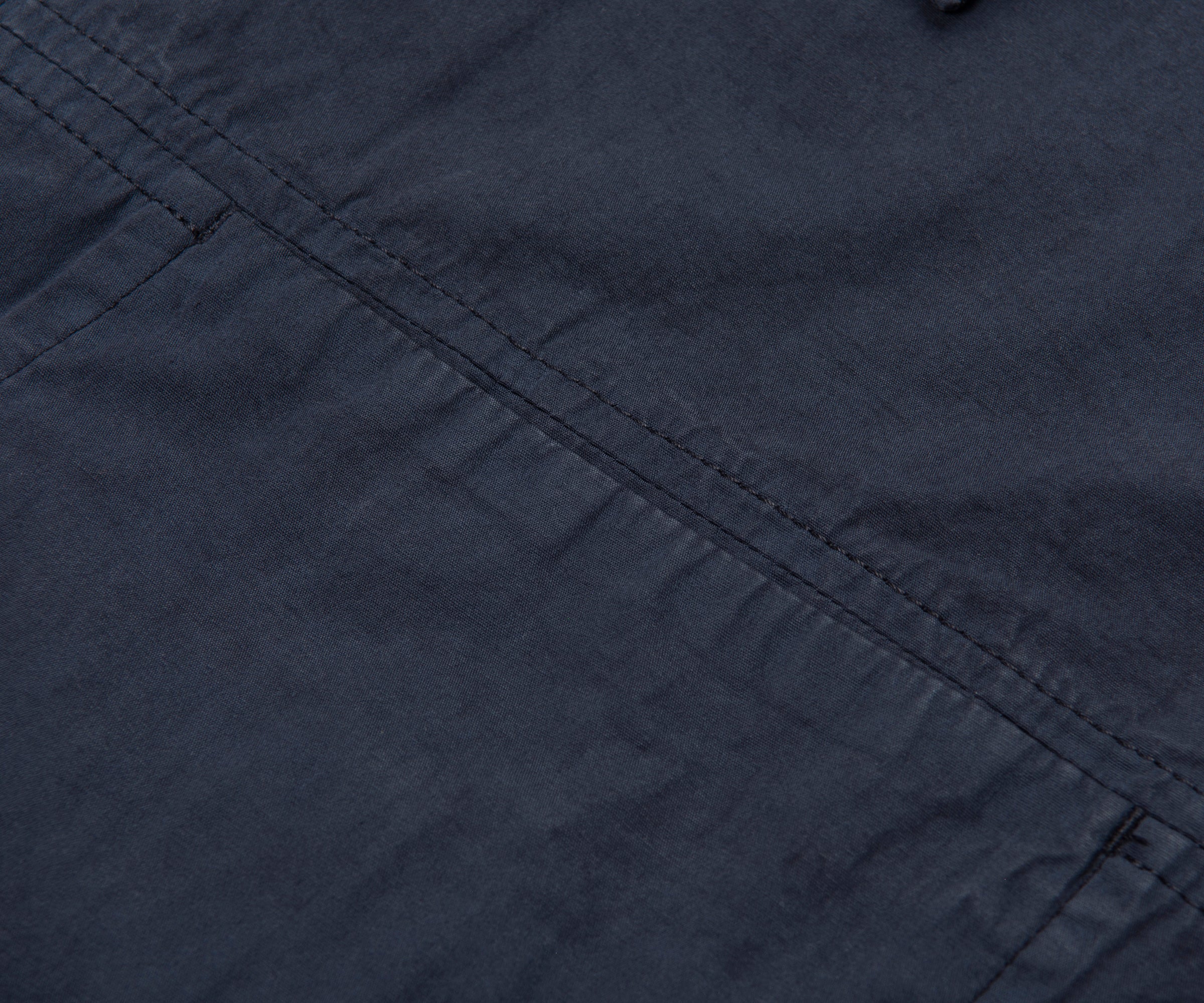 Close-up of dark blue fabric with visible stitching