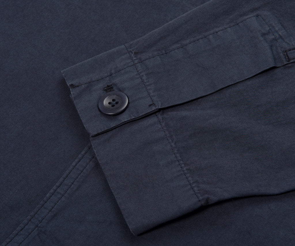 Close-up of a dark gray pocket with a button on a textured fabric background