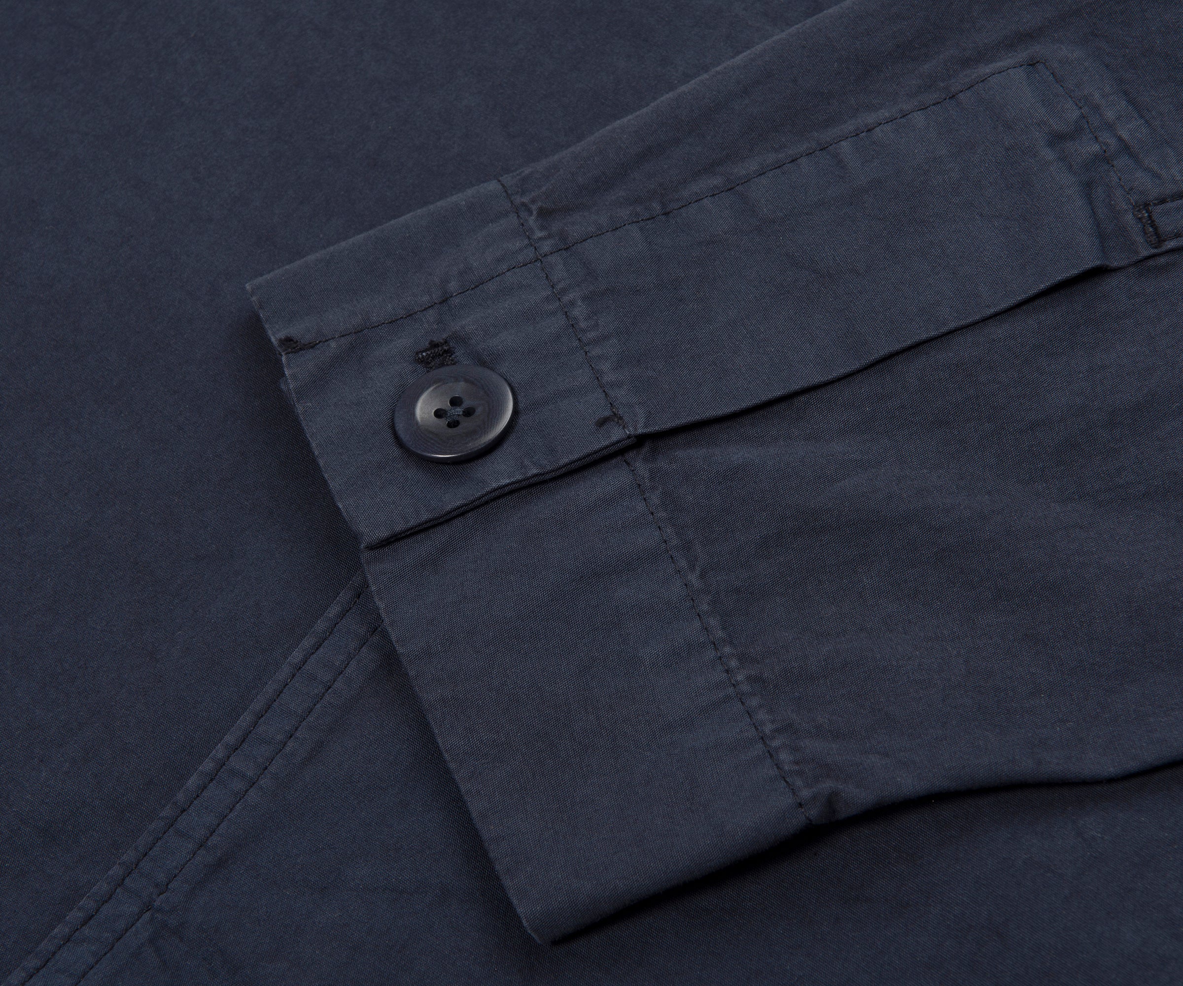 Close-up of a dark gray pocket with a button on a textured fabric background