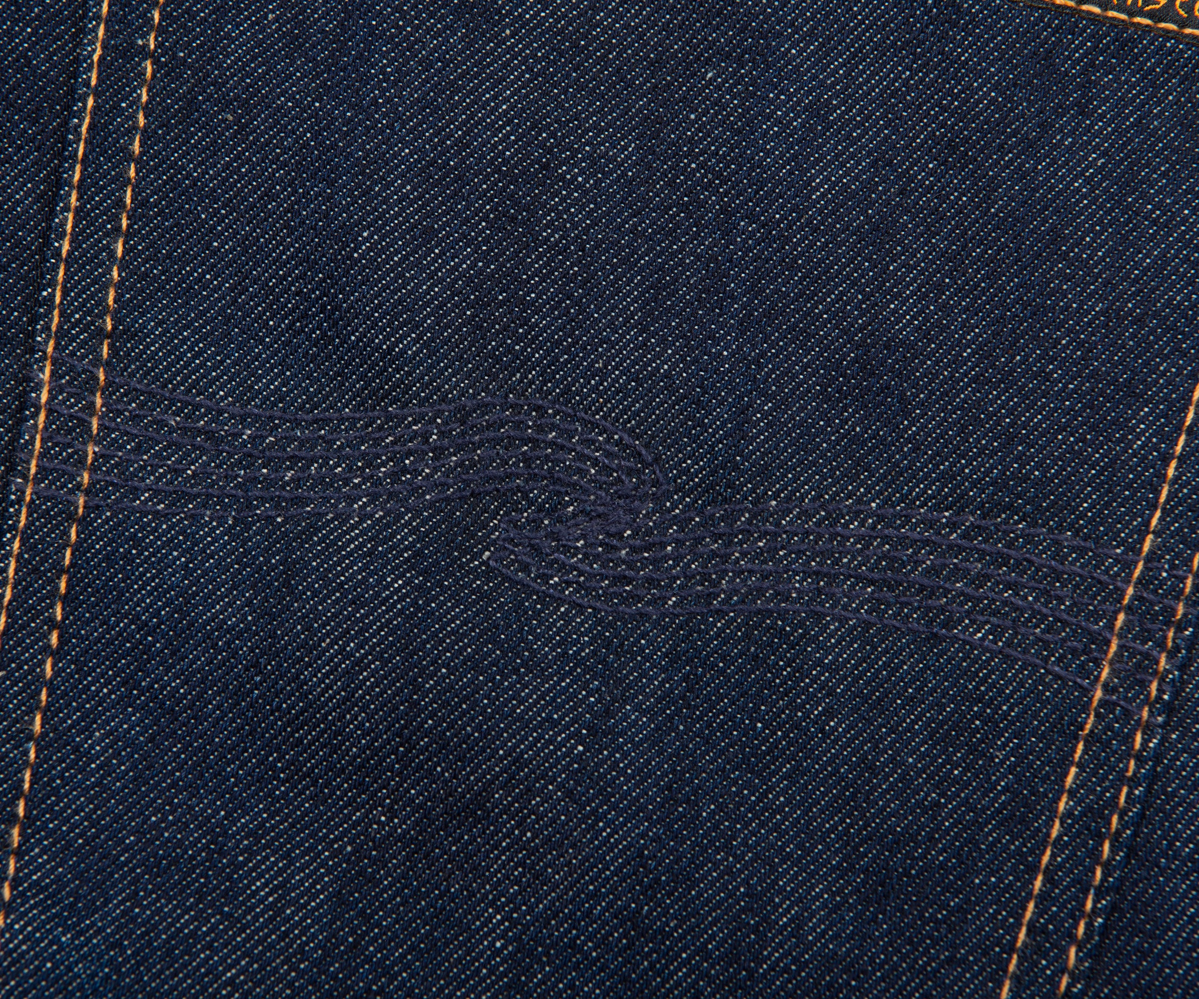 Close-up of blue denim fabric with stitching details