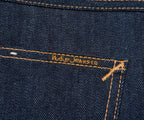 Close-up of a blue denim fabric with 'Nude Jeans Co.' branding.