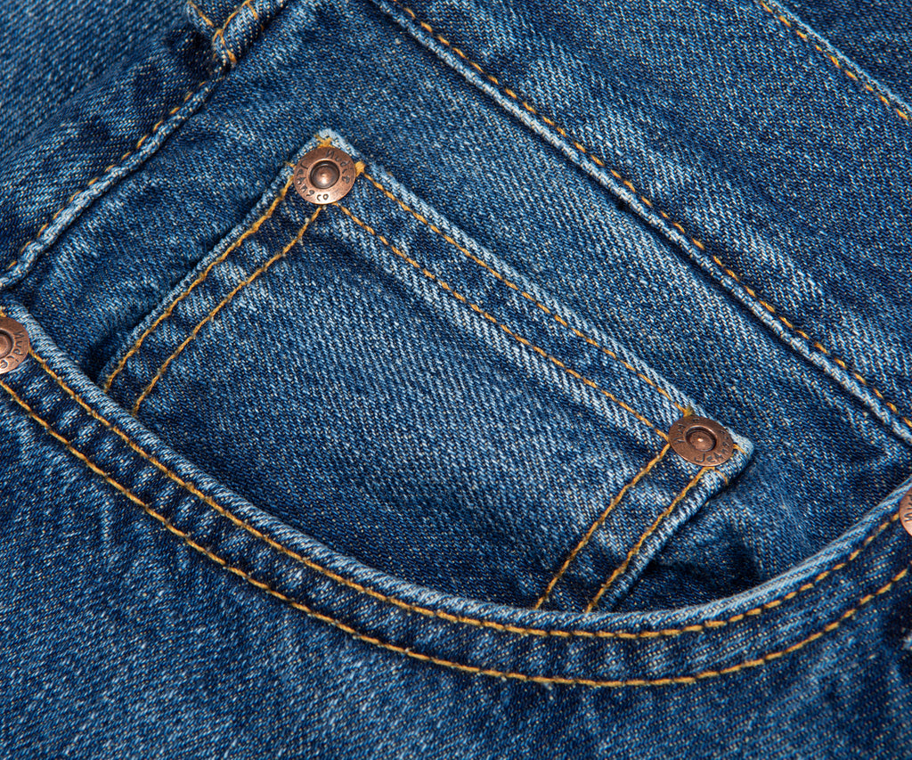 Close-up of a blue denim pocket with stitching details