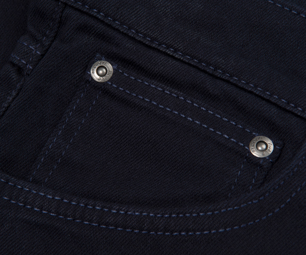 Close-up of a black denim pocket with metal buttons