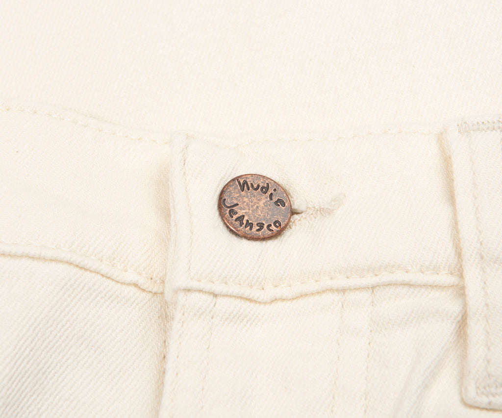 Close-up of a white denim jacket with a brand label on a white background