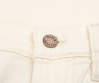 Close-up of a white denim jacket with a brand label on a white background