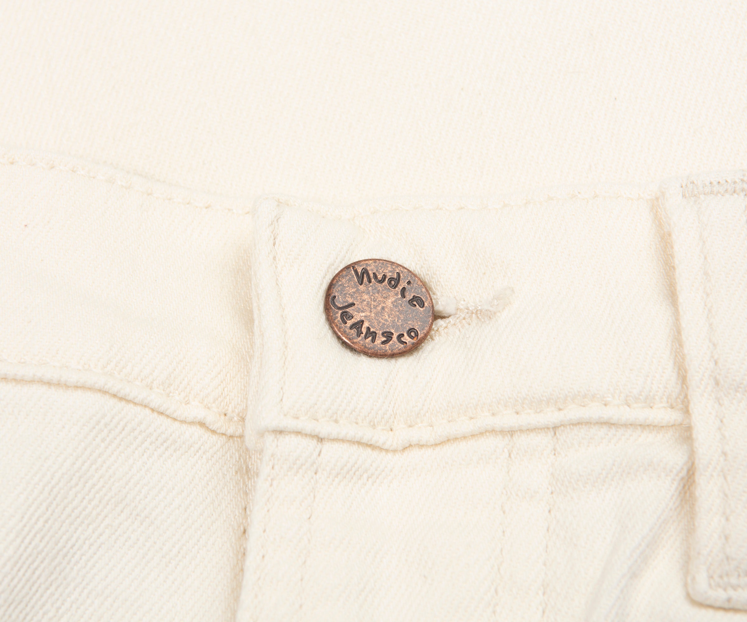 Close-up of a white denim jacket with a brand label on a white background