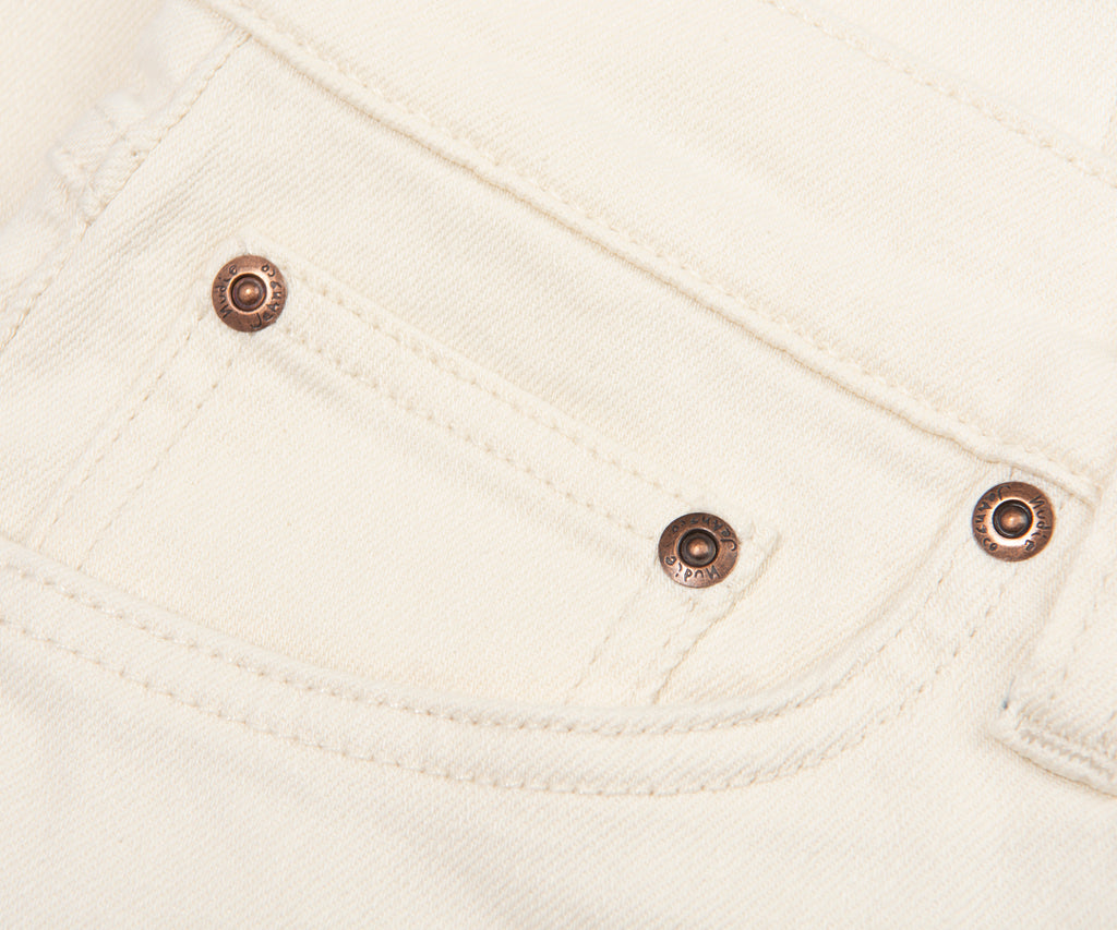 Close-up of a white fabric pocket with metal buttons.