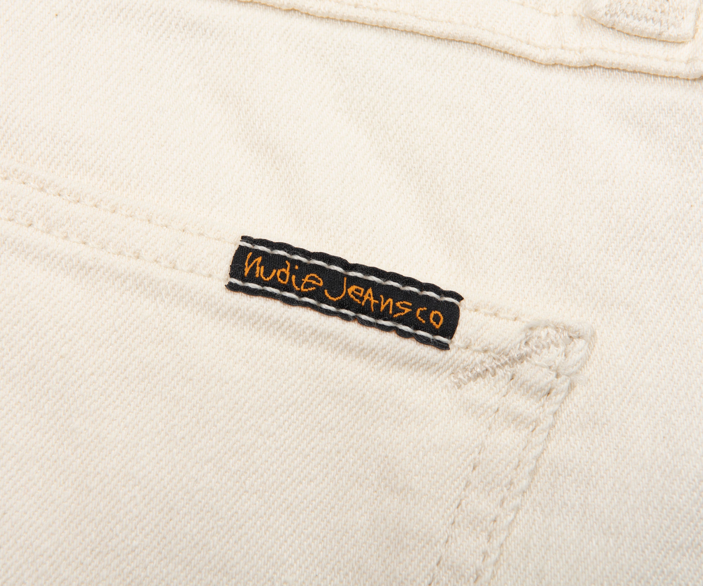 Nudie JeansCo label on a beige denim fabric