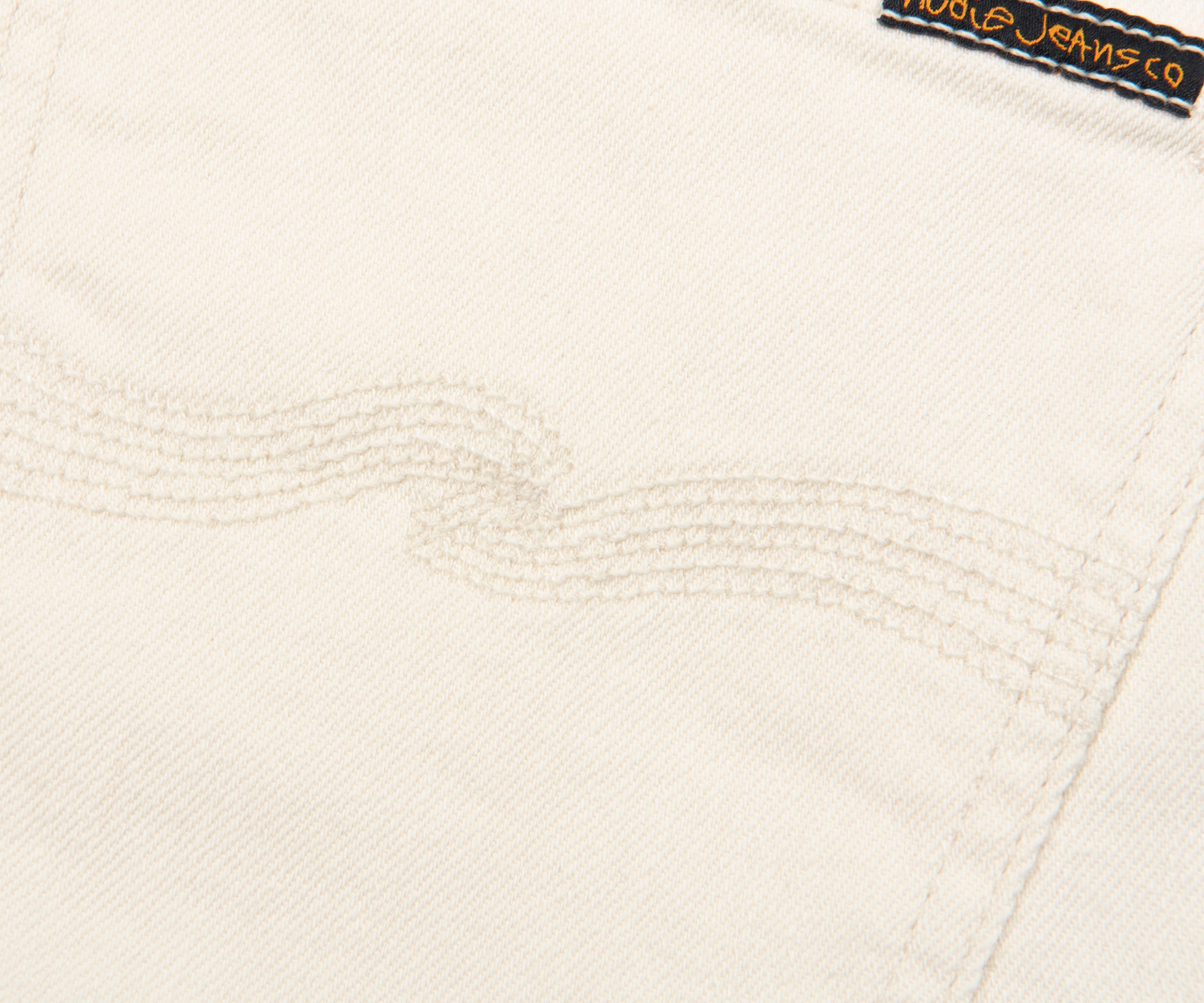 Close-up of a textured white fabric with a brand label in the corner.