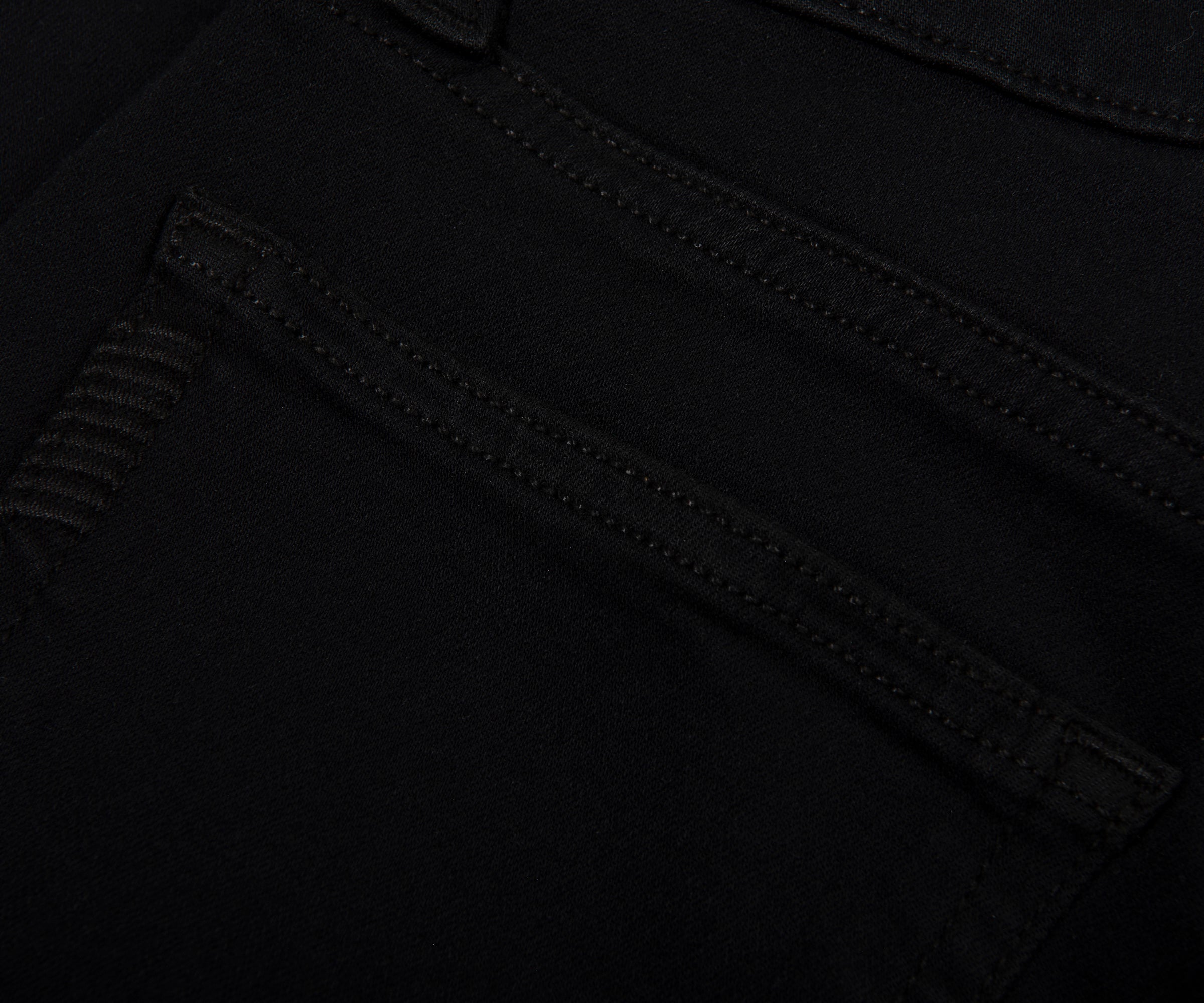 Close-up of black pants with a focus on stitching detail.