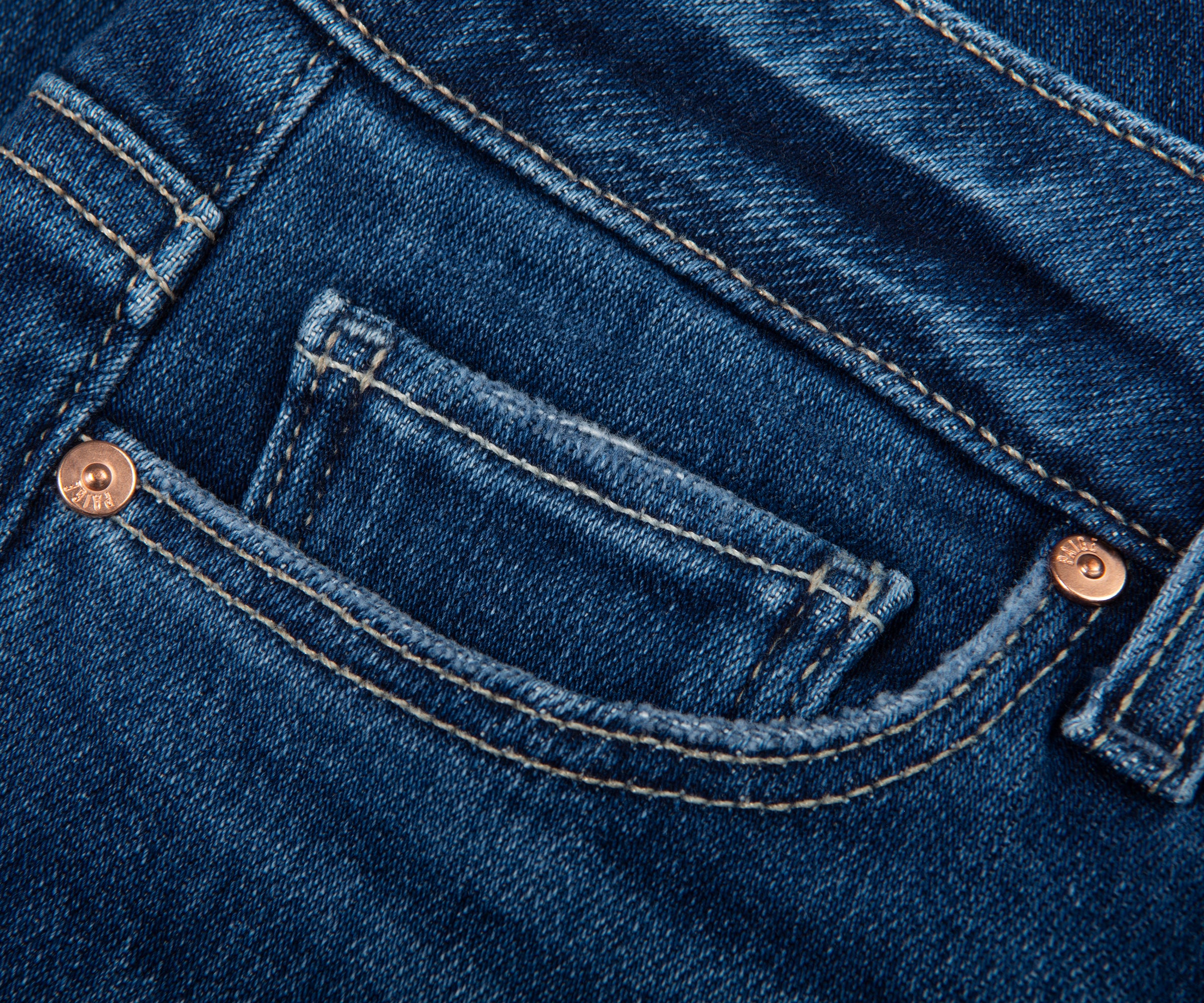 Close-up of blue denim jeans with stitching and buttons.