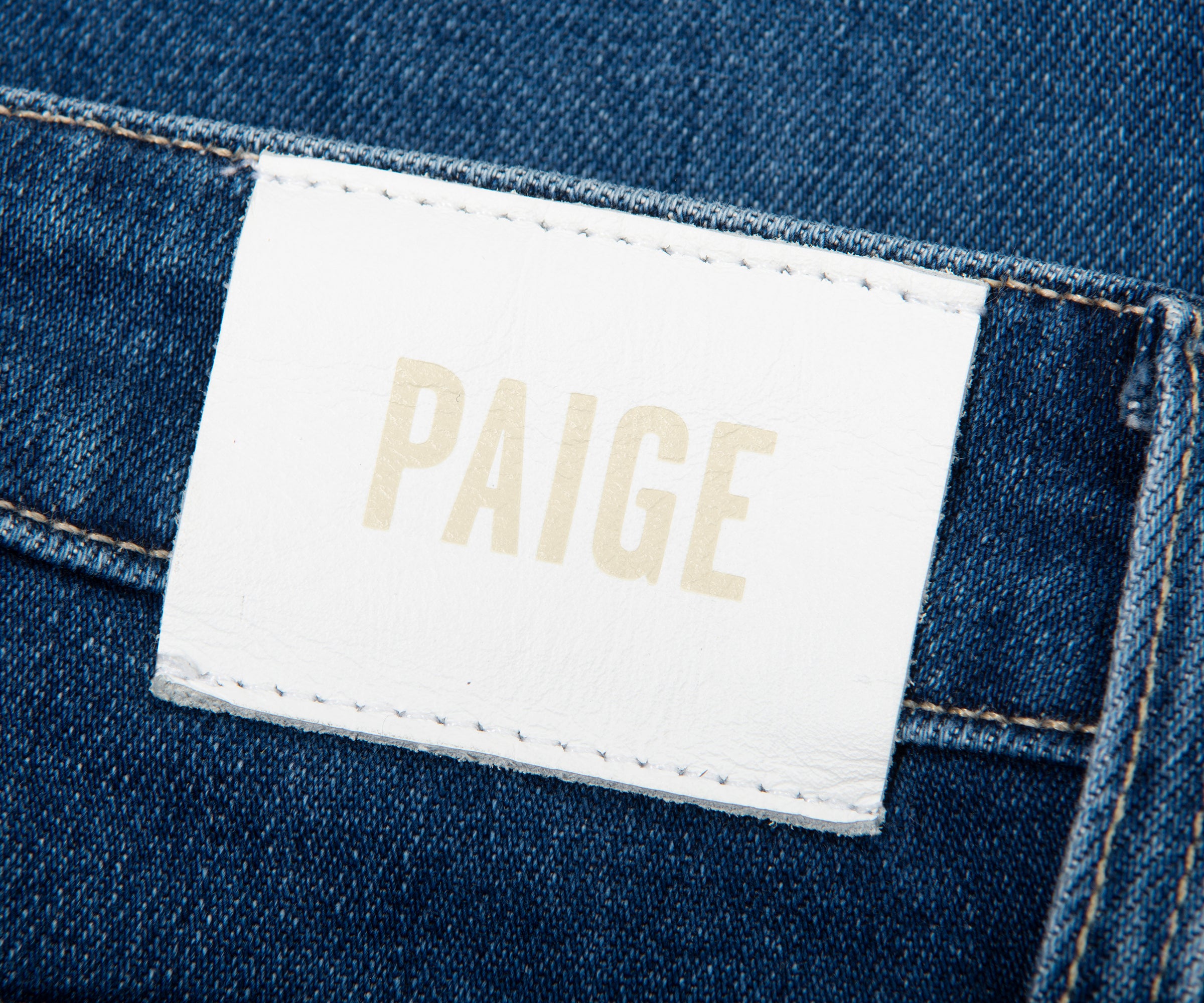 Paige denim label on a blue denim fabric background