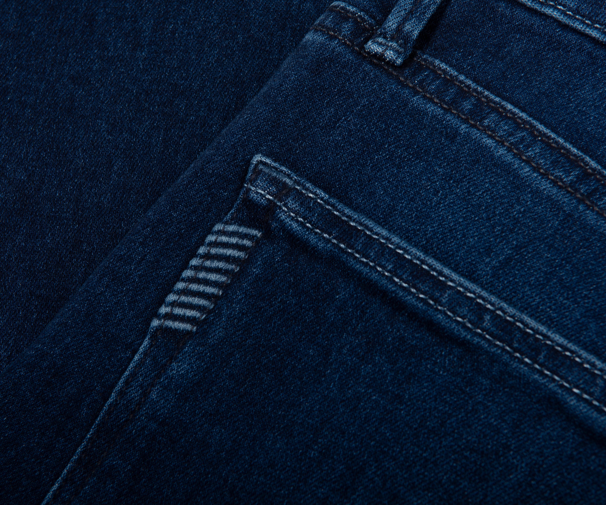 Close-up of blue denim fabric with stitching details