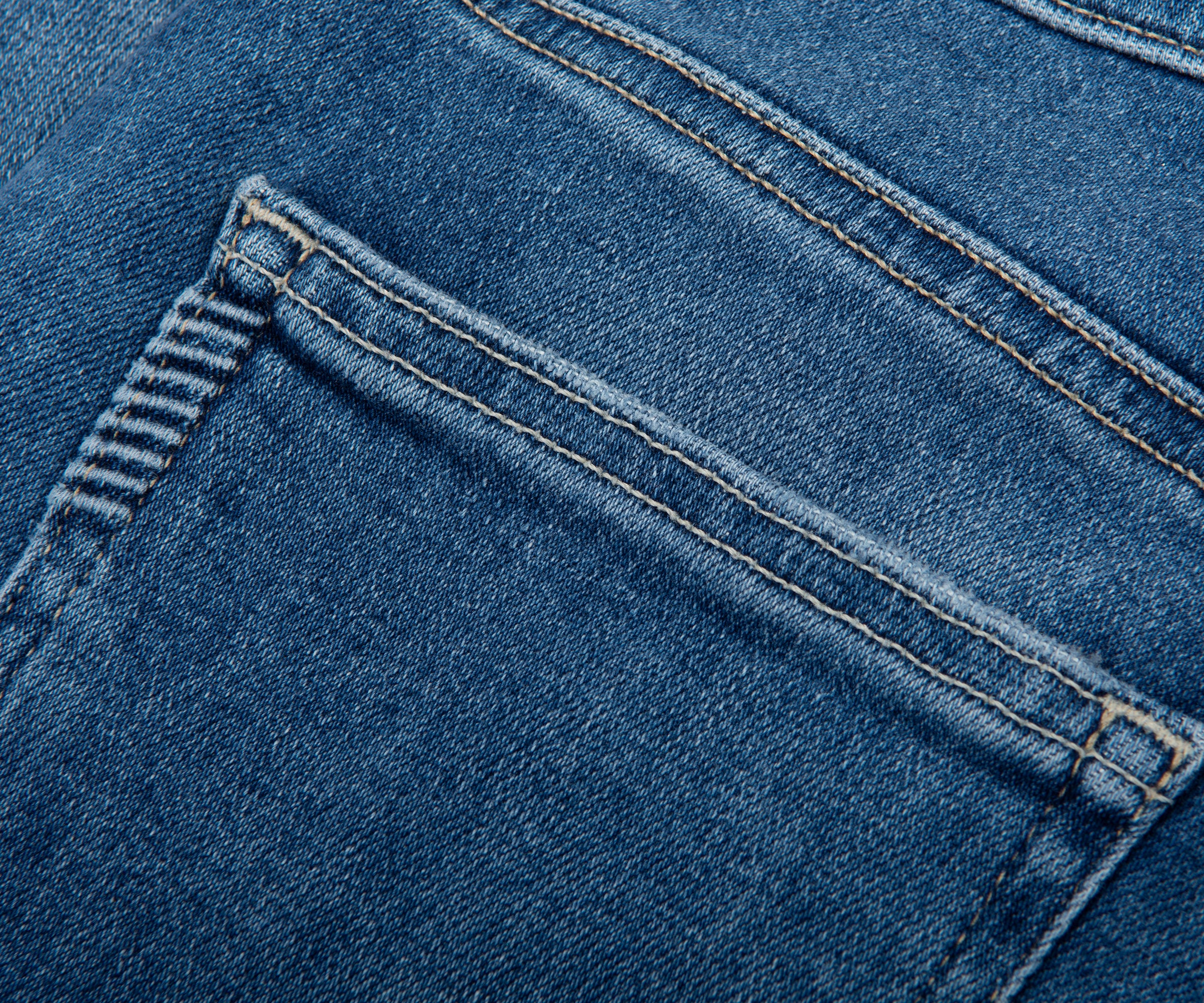 Close-up of blue denim fabric with stitching details