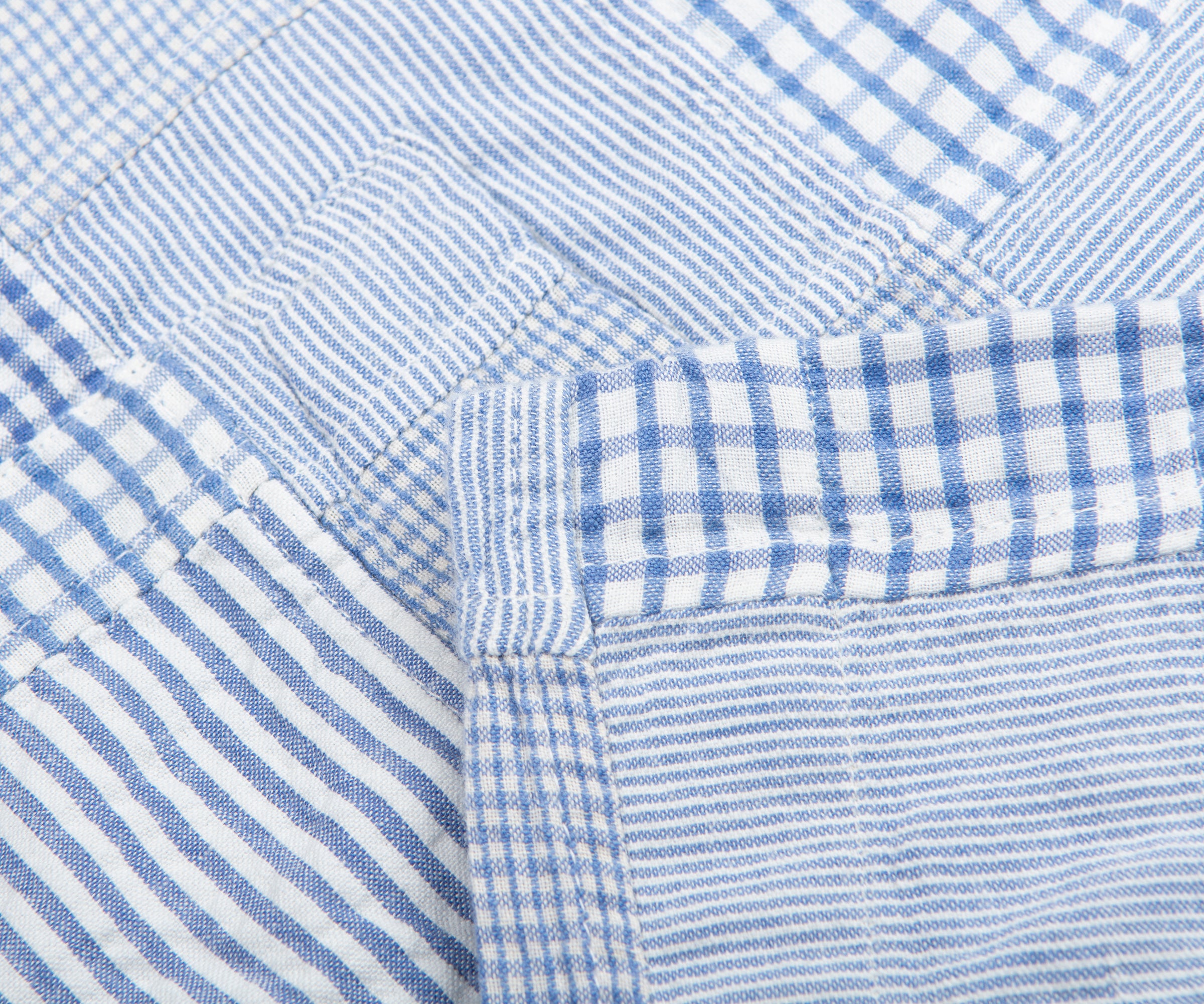 Close-up of blue and white checkered fabric with a pocket detail.
