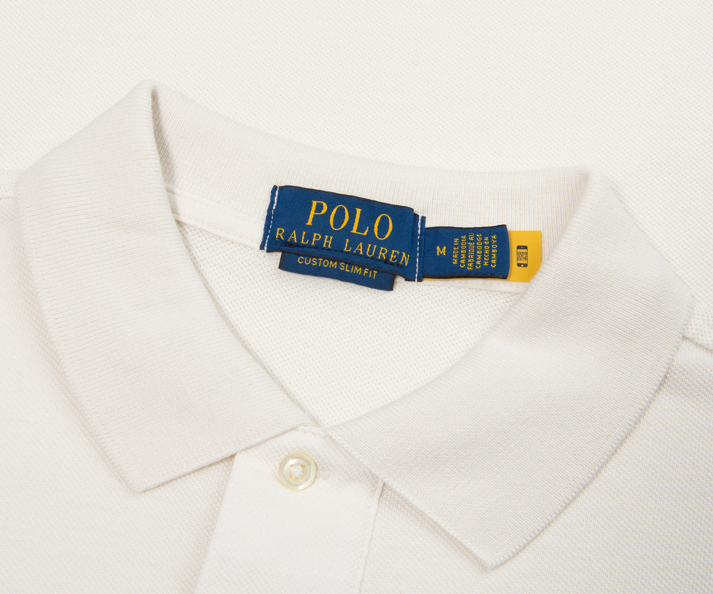 Close-up of a white shirt with a Polo Ralph Lauren tag on a light gray background
