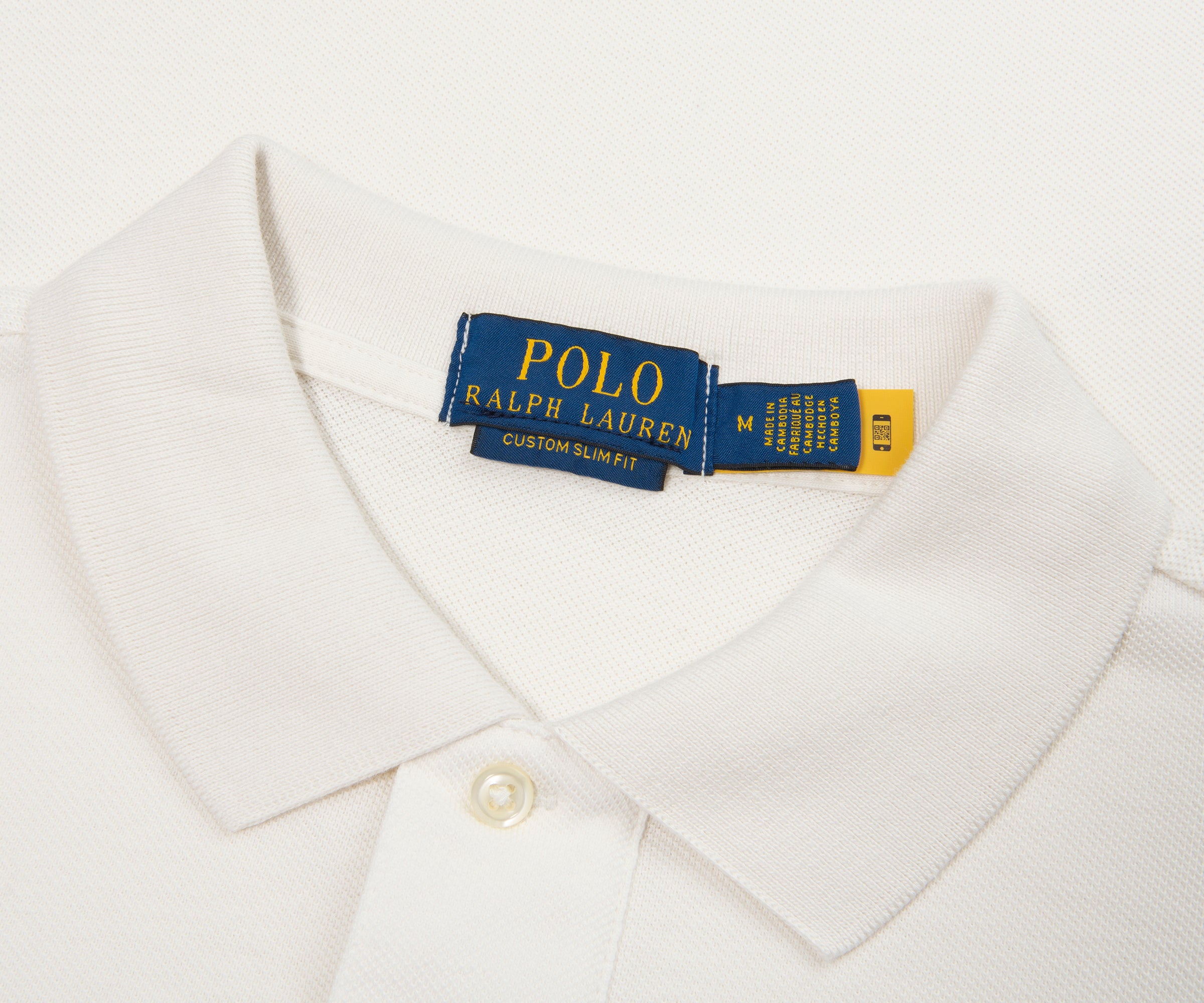 Close-up of a white shirt with a Polo Ralph Lauren tag on a light gray background