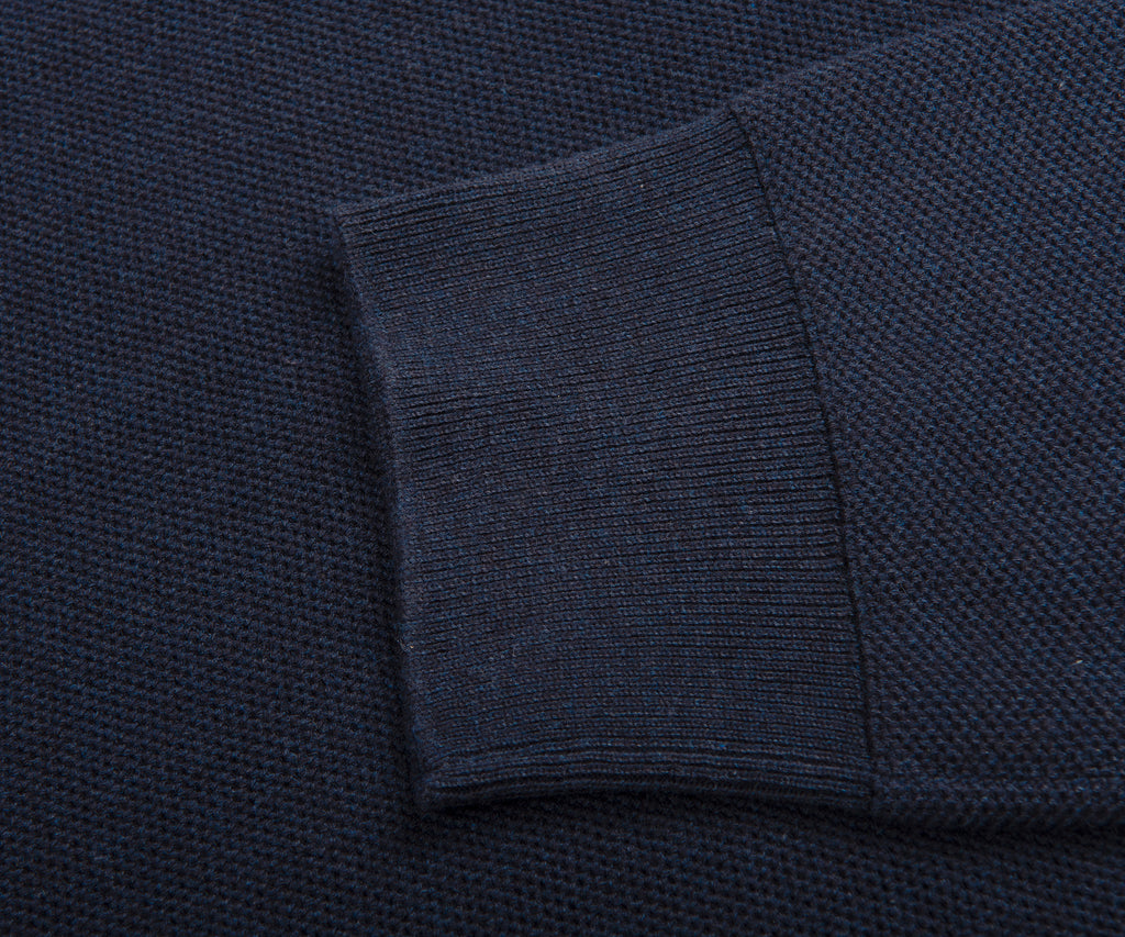 Close-up of a dark blue textured fabric with a folded edge.