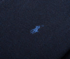 Close-up of a dark blue fabric with a small embroidered logo.