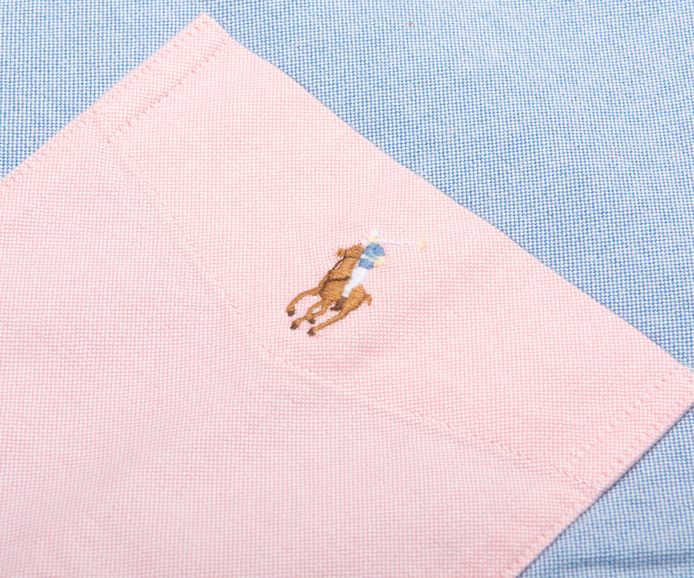 Pink fabric with embroidered bear design on a blue checkered background