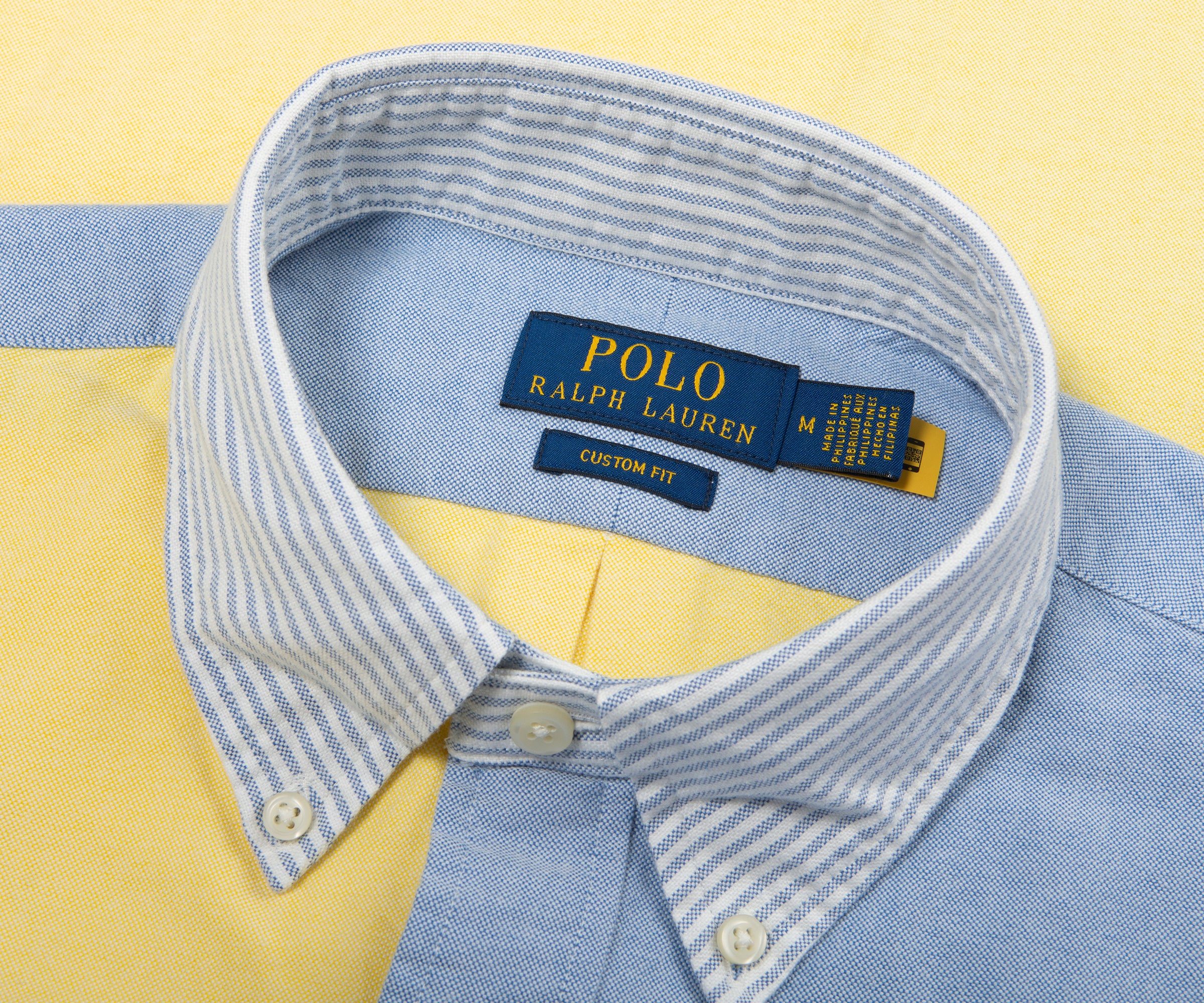 Close-up of a Polo Ralph Lauren shirt collar with visible branding on a yellow background