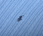 Close-up of a blue textured fabric with a logo in the center.
