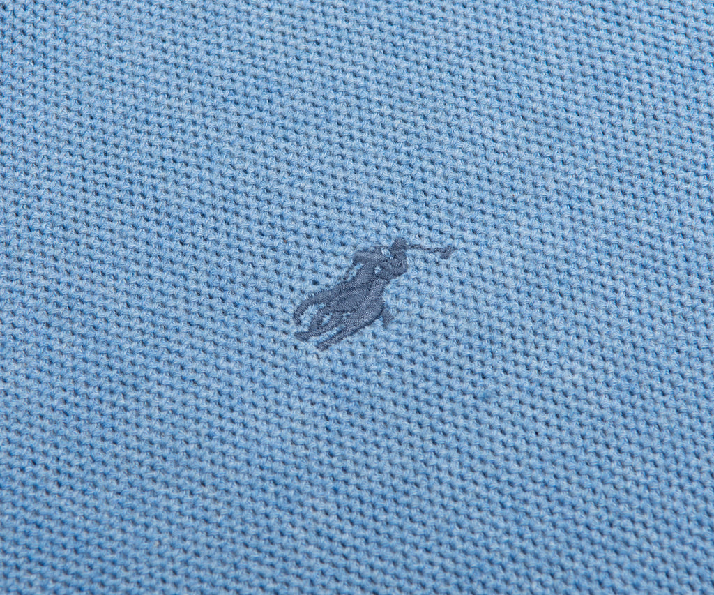 Close-up of a textured blue fabric with a small logo or emblem.