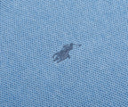 Close-up of a textured blue fabric with a small logo or emblem.